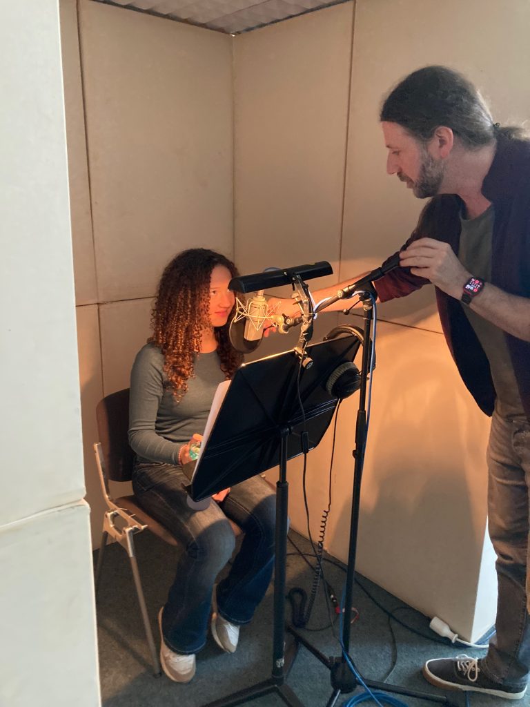Schülerin spricht einen Podcast-Beitrag am Mikrofon ein